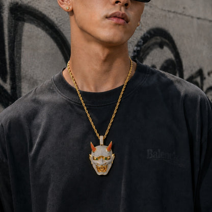 Male model wearing the ICEDIAMOND 18k gold finish LET LIGHT IN Oni mask pendant necklace with a streetwear outfit.
