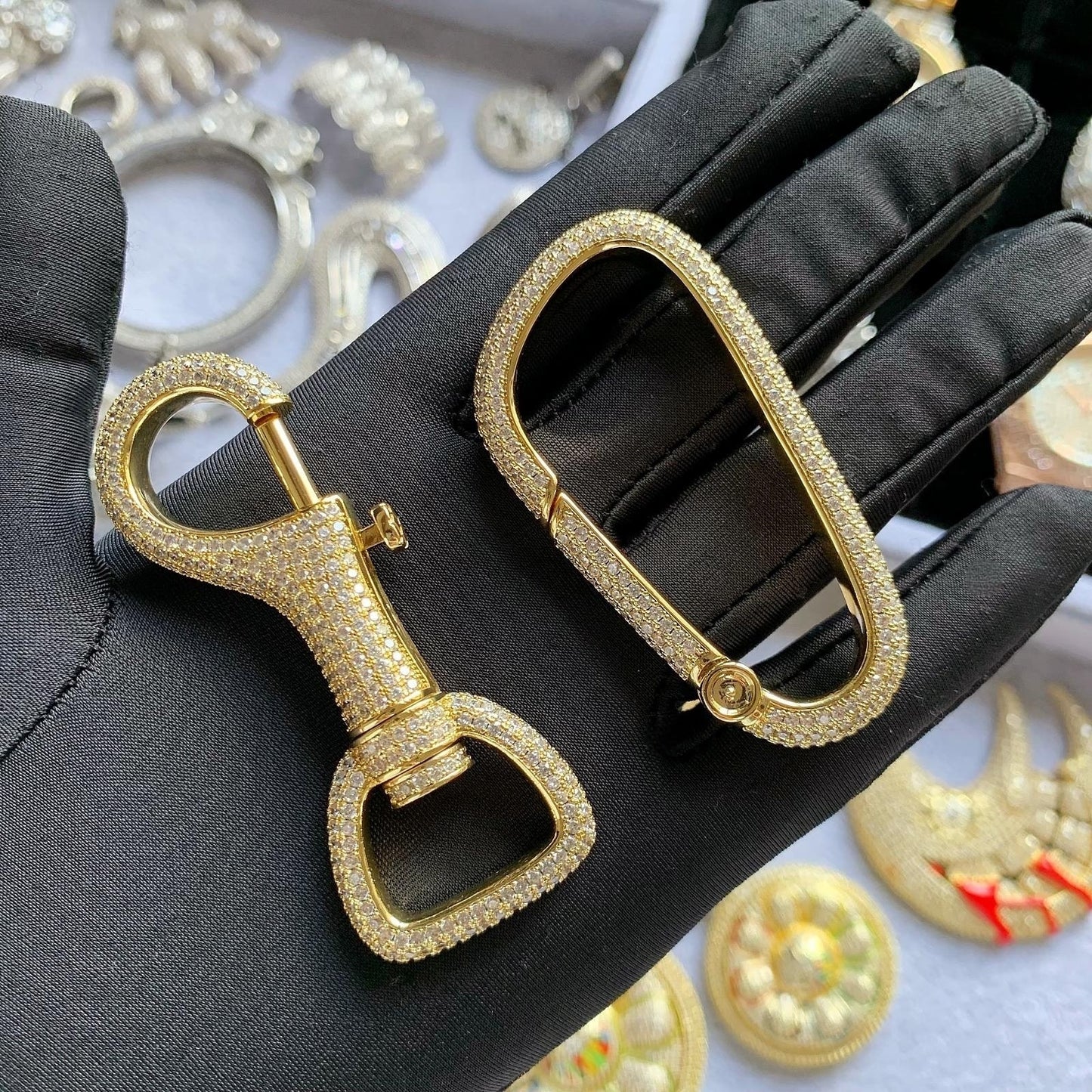 Close-up of hand-set 5A cubic zirconia stones on a luxury brass carabiner
