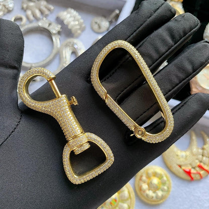Close-up of hand-set 5A cubic zirconia stones on a luxury brass carabiner

