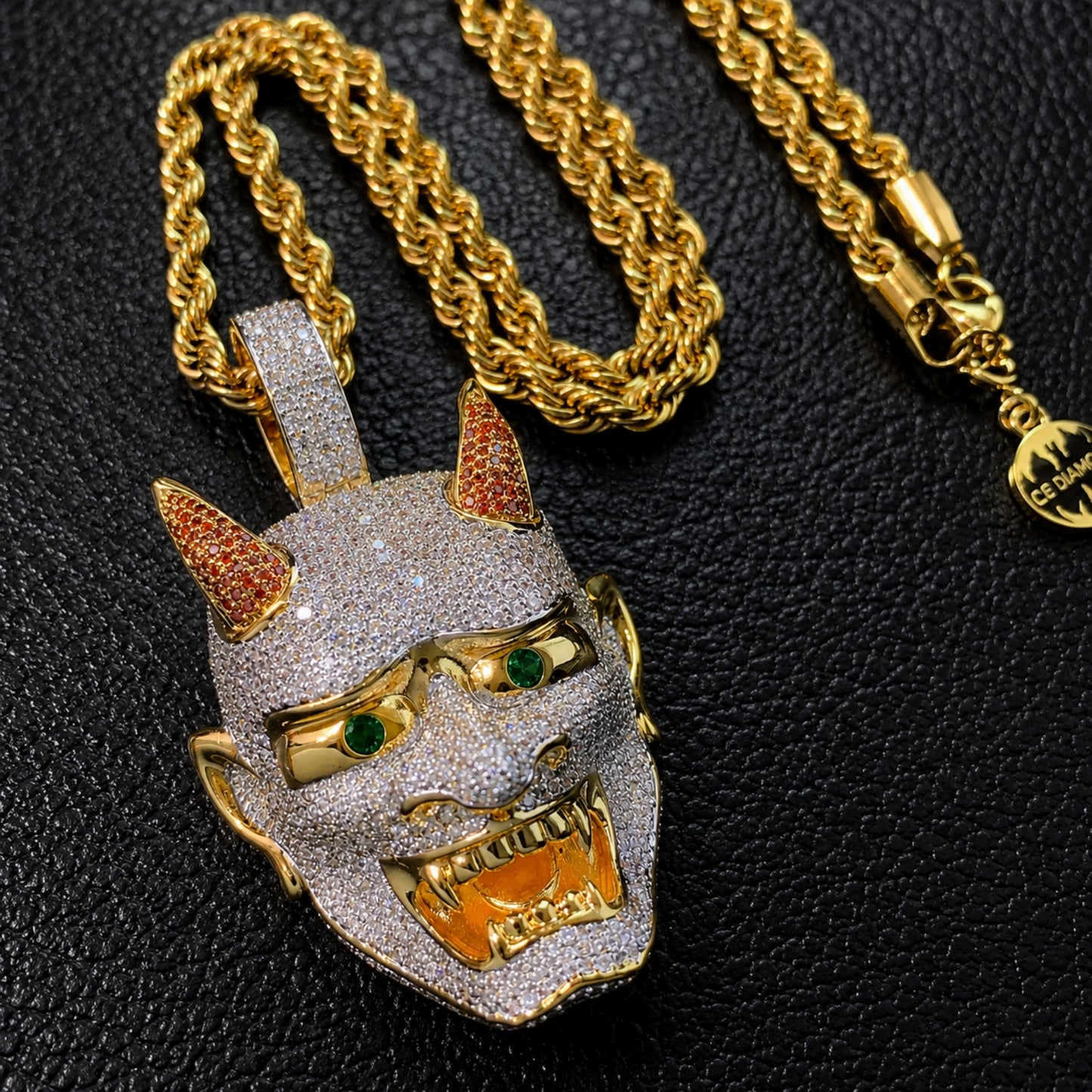 Close-up of the LET LIGHT IN Oni mask pendant showing hand-set 5A cubic zirconia and detailed craftsmanship.
