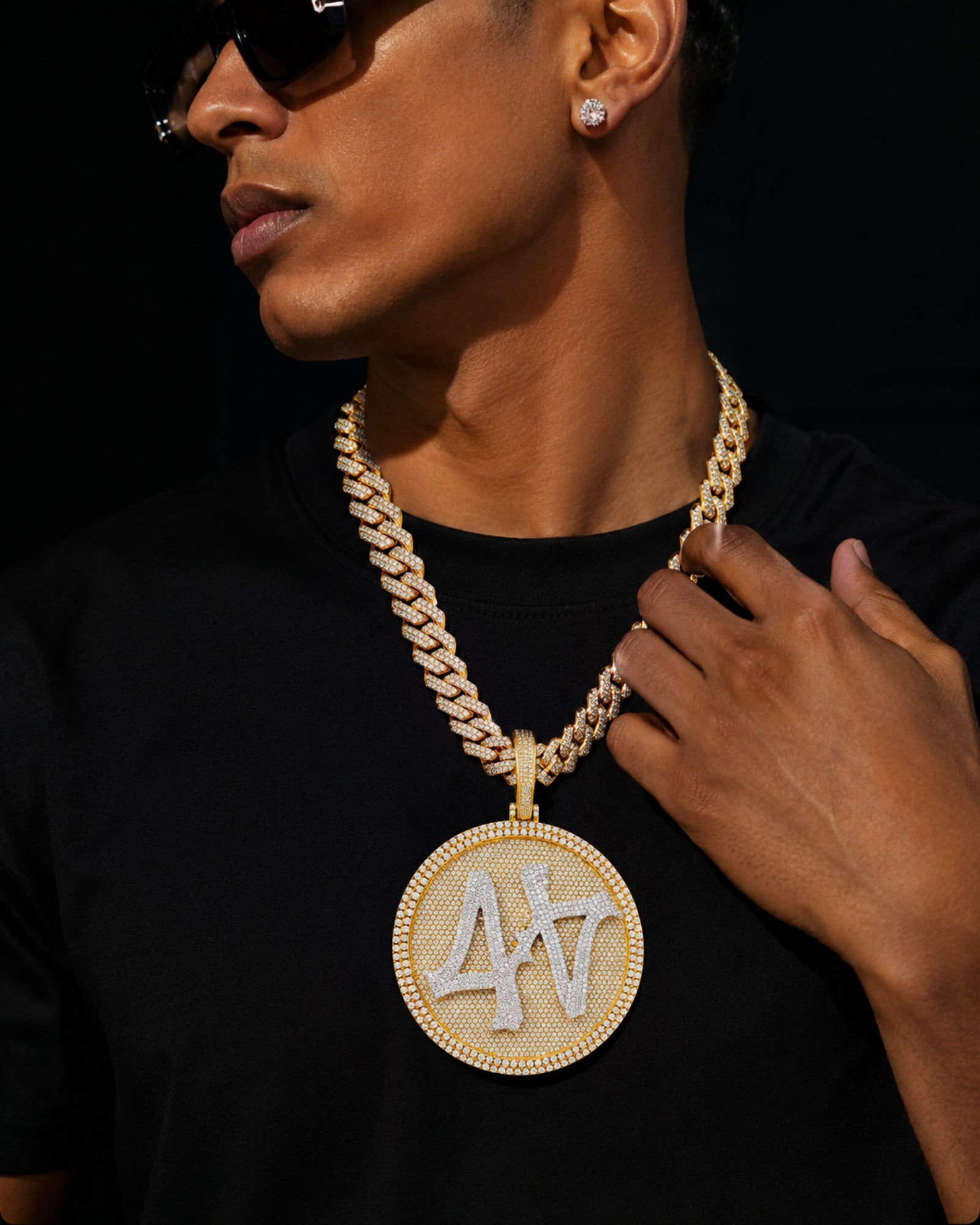 Model wearing the 14k gold finished ICEDIAMOND TURN THE GAME oversized spinner pendant necklace with 14mm iced out cuban chain.
