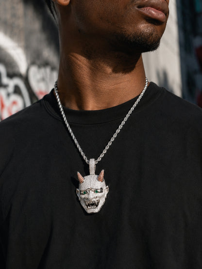 Male model wearing the ICEDIAMOND 18k white gold finish LET LIGHT IN Oni mask pendant necklace with a streetwear outfit.
