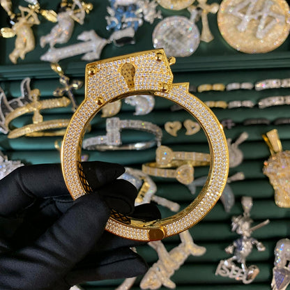 Model holding ICEDIAMOND LIVE UNBOUND adjustable lock-inspired bangle bracelets in gold and white gold finishes.
